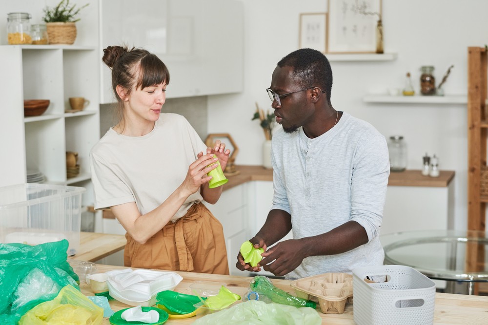 Young,Couple,Sorting,The,Rubbish,Together,In,The,Kitchen,At